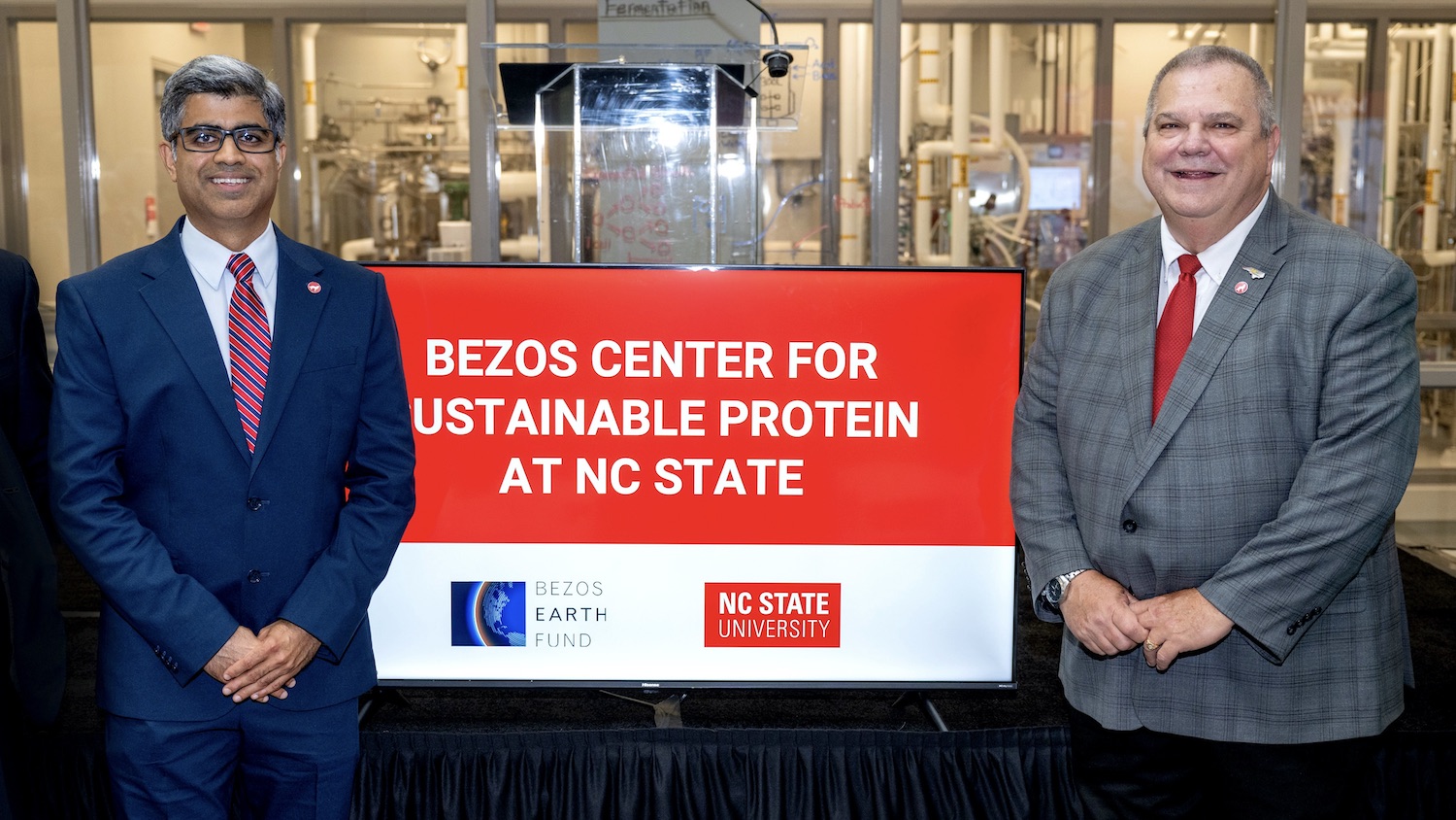 Bill Aimutis and Rohan stand beside Bezos Center signage.