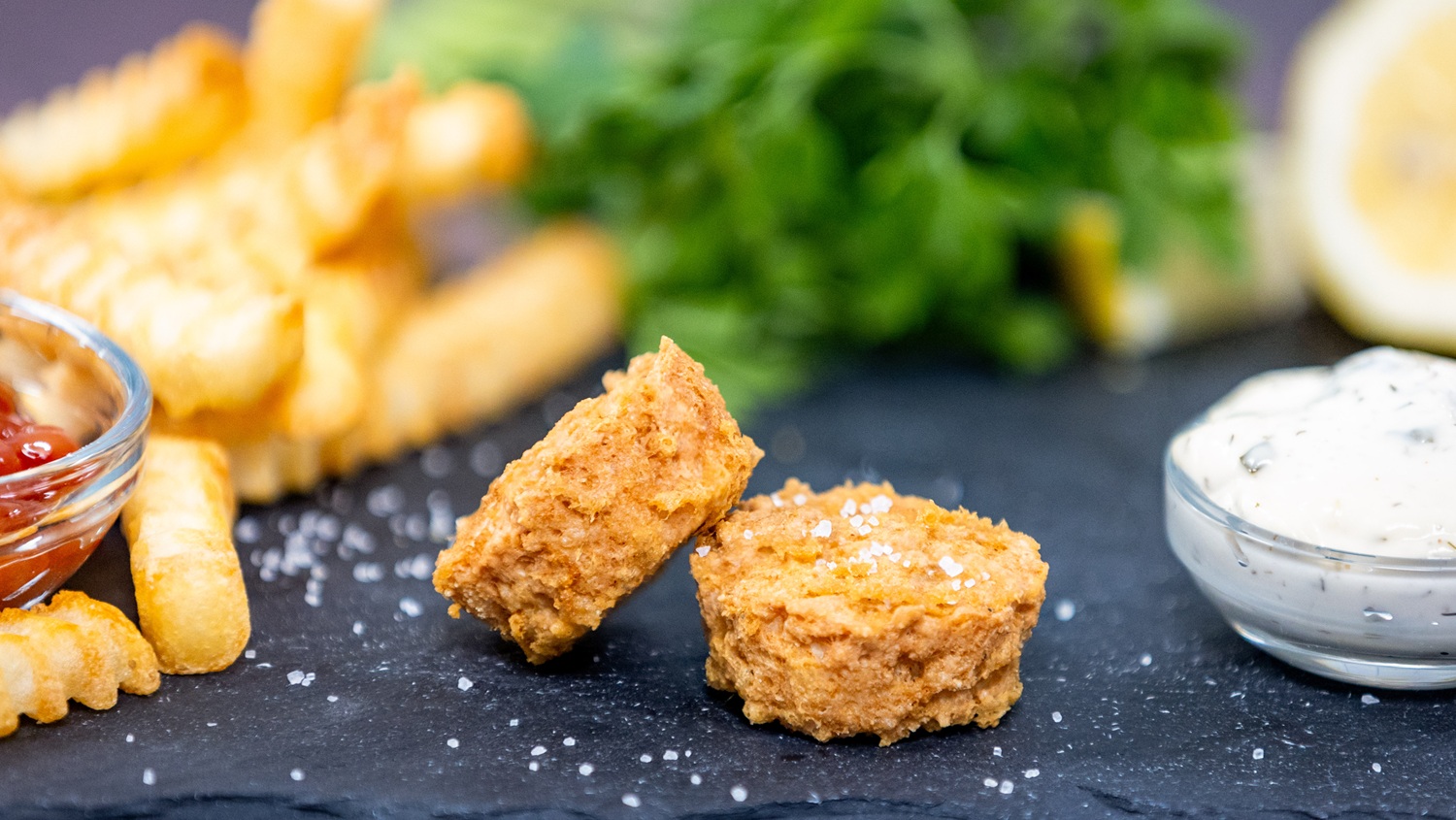 Two alternative protein fish nuggets with sauce and french fries