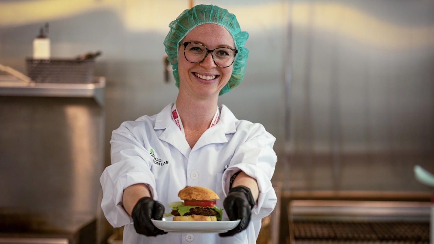Elise Packer presents a food sample while working in the NCFIL lab.