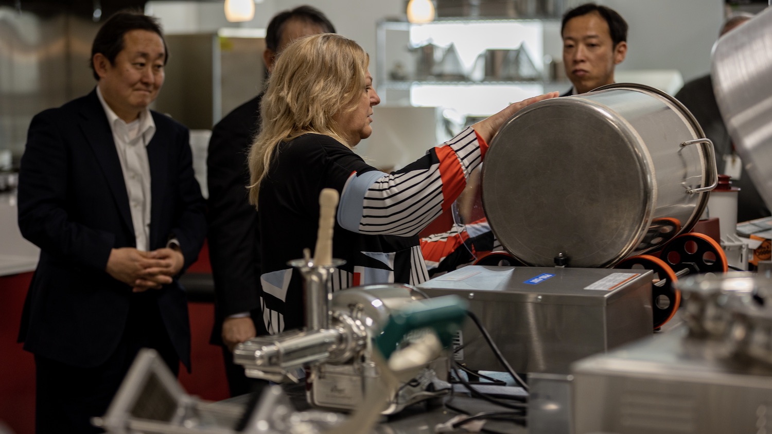 Three men and one woman food scientist demonstrating lab equipment