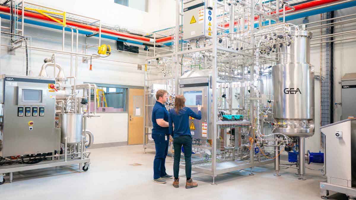 Two people standing in front of steel equipment