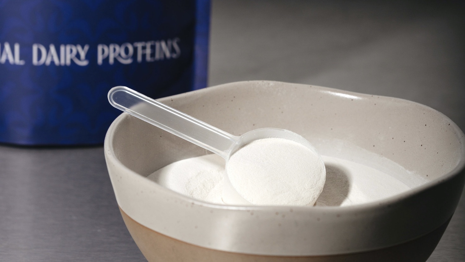 Photo of a bowl of Verley dairy protein powder with a tablespoon in powder