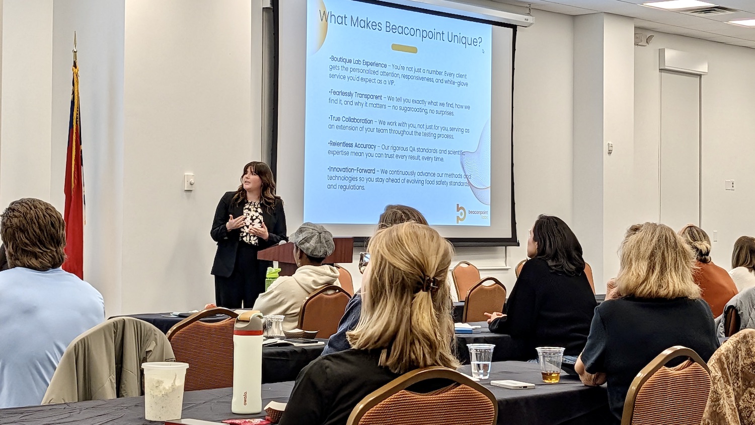 Food safety professional speaking to an audience with PowerPoint in background