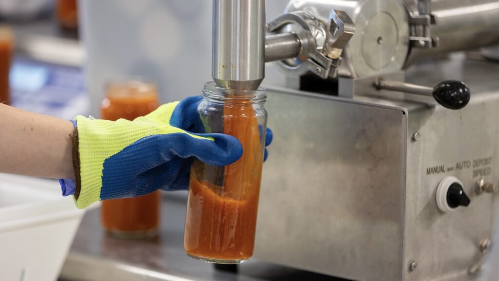 Soup being filled in glass container in a NCFIL lab