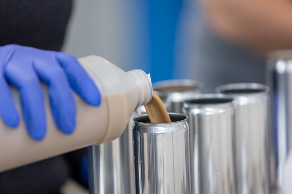 Image of someone's hand pouring liquid into a vessel.